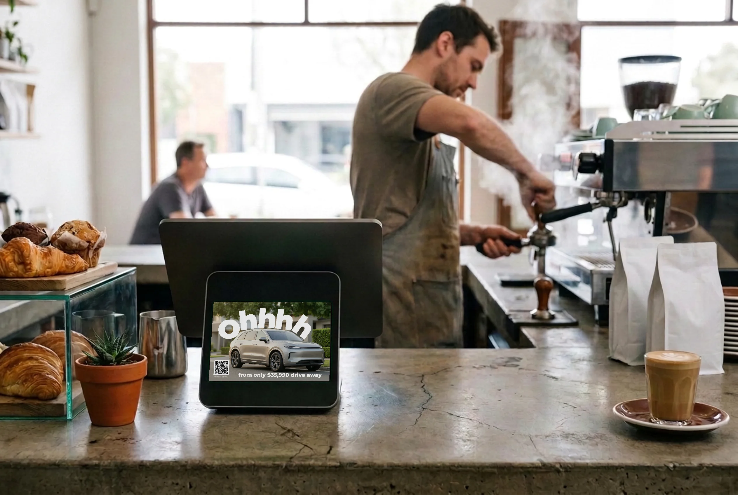 A full-screen electric-SUV ad on the customer-facing counter screen in a busy café.